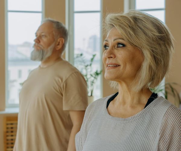 A group of people of different ages in a bright yoga class.